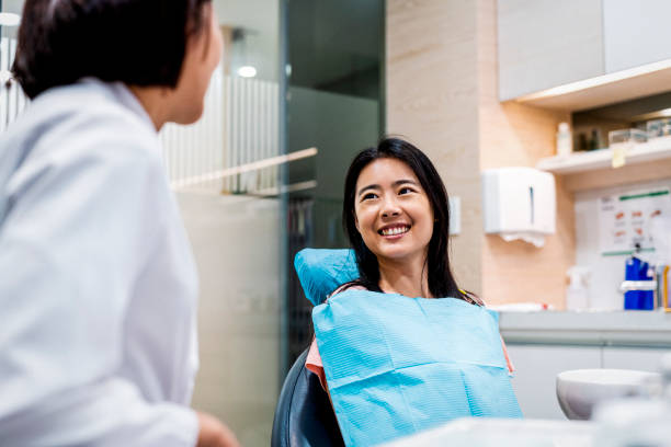 a woman smiling at her emergency dentist